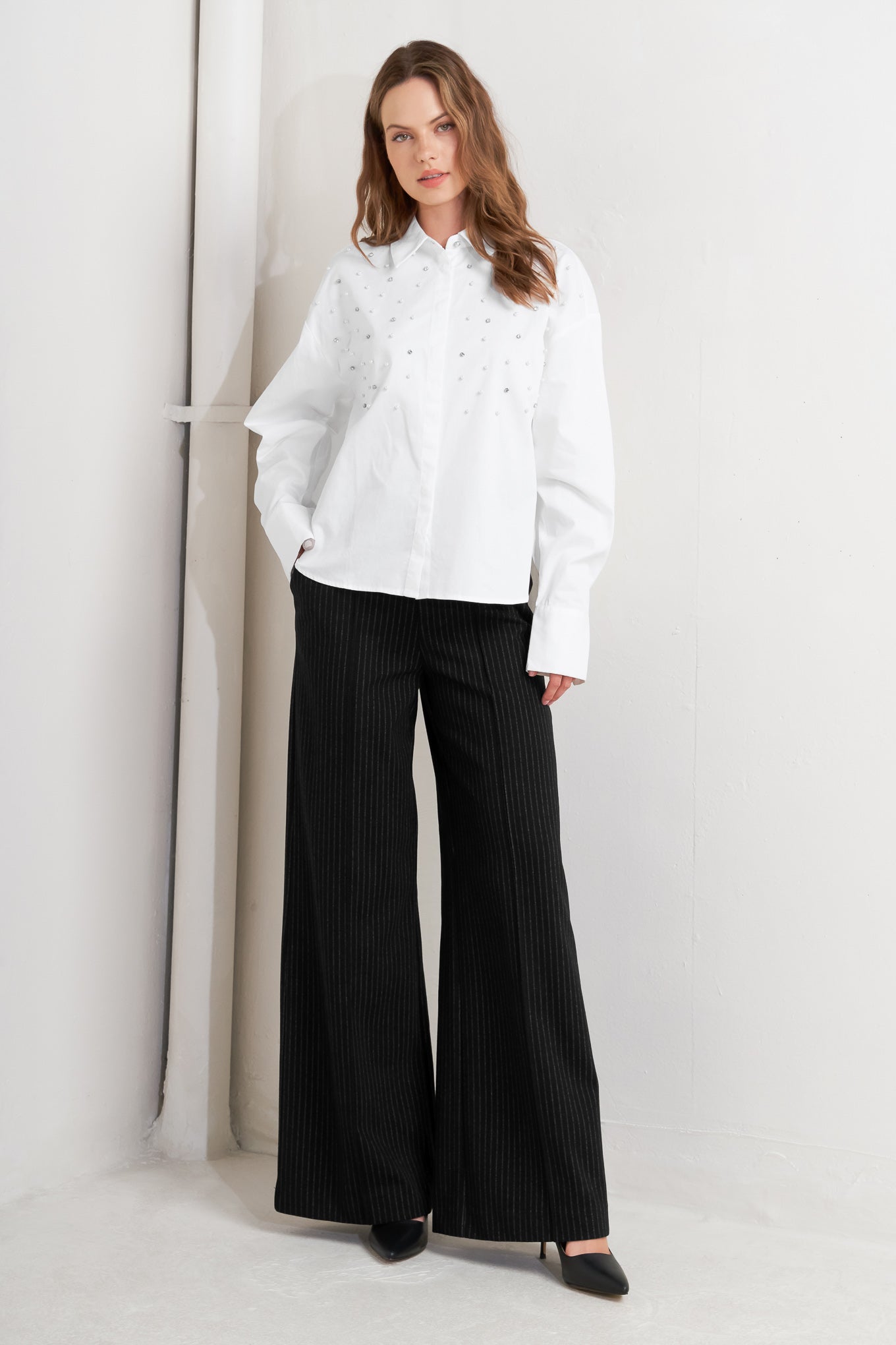 A woven shirt featuring collar, long sleeve, front button down and embellishment