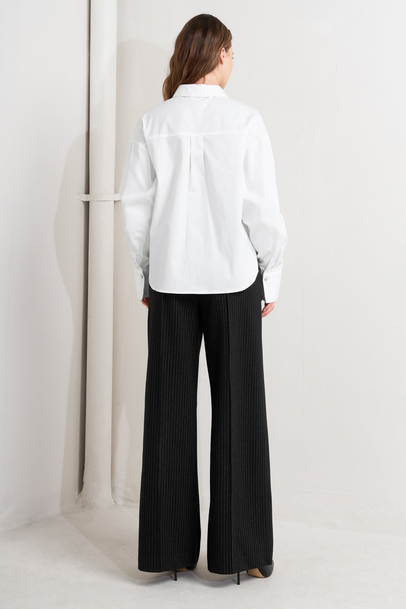 A woven shirt featuring collar, long sleeve, front button down and embellishment