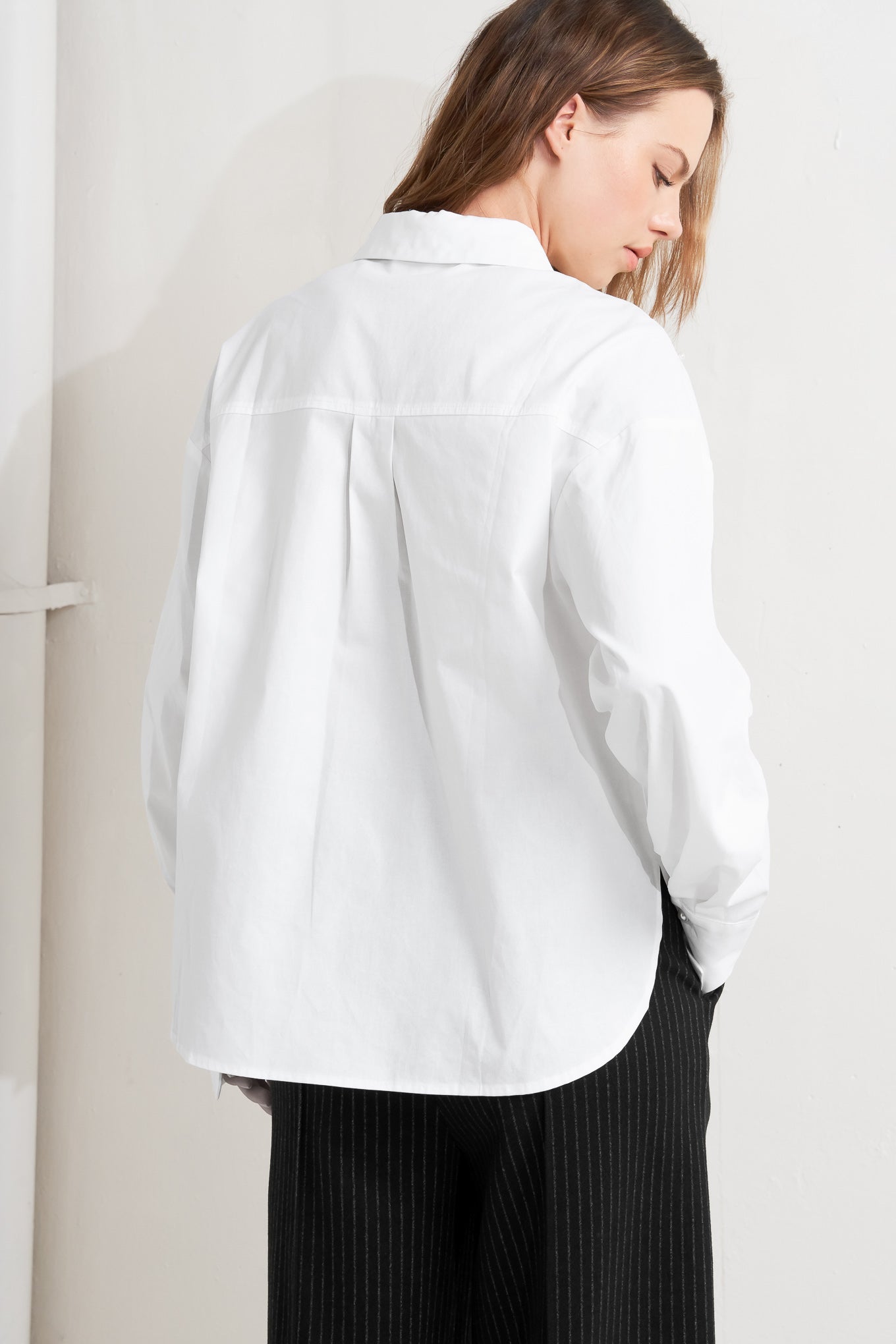 A woven shirt featuring collar, long sleeve, front button down and embellishment