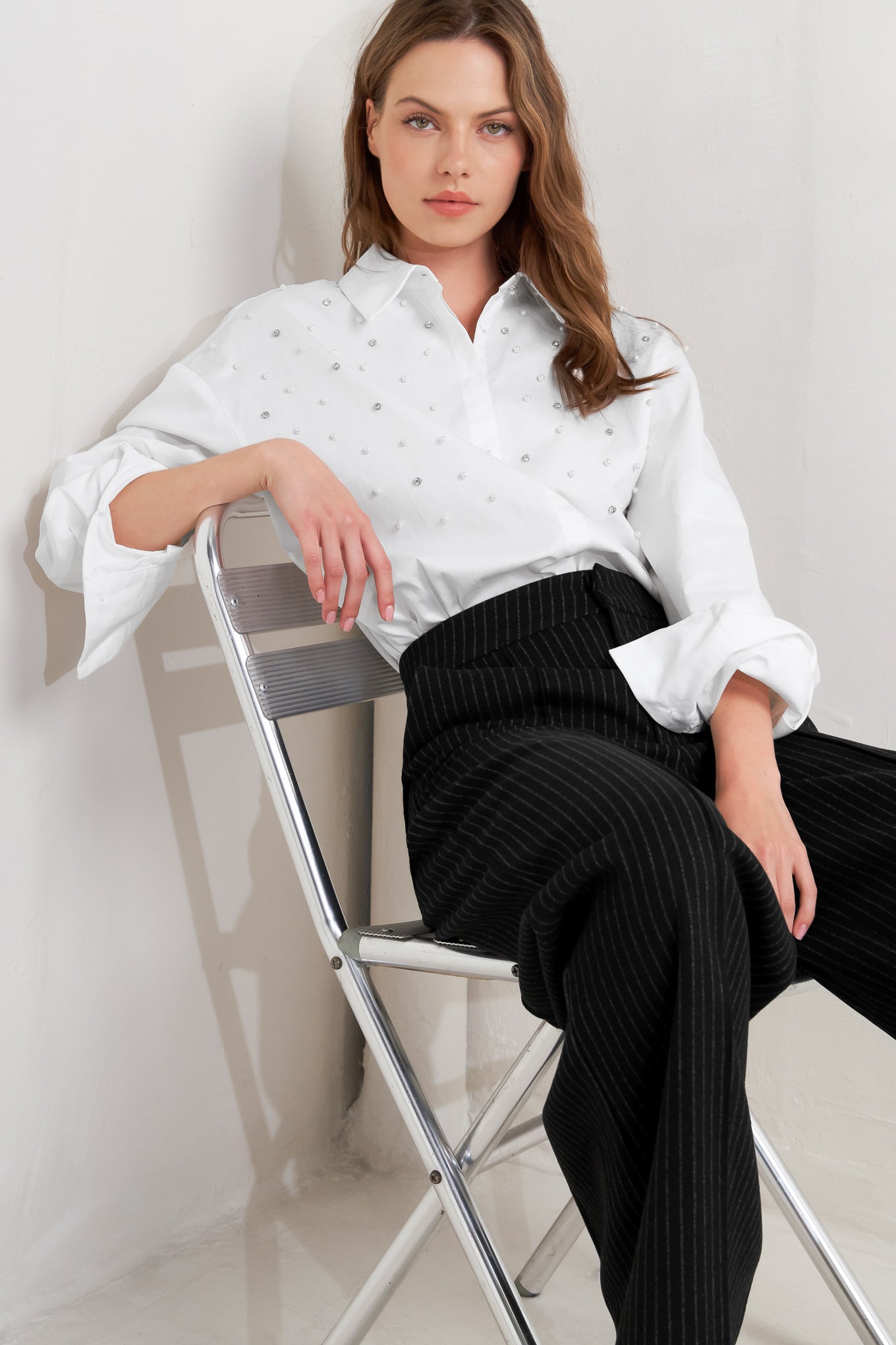A woven shirt featuring collar, long sleeve, front button down and embellishment
