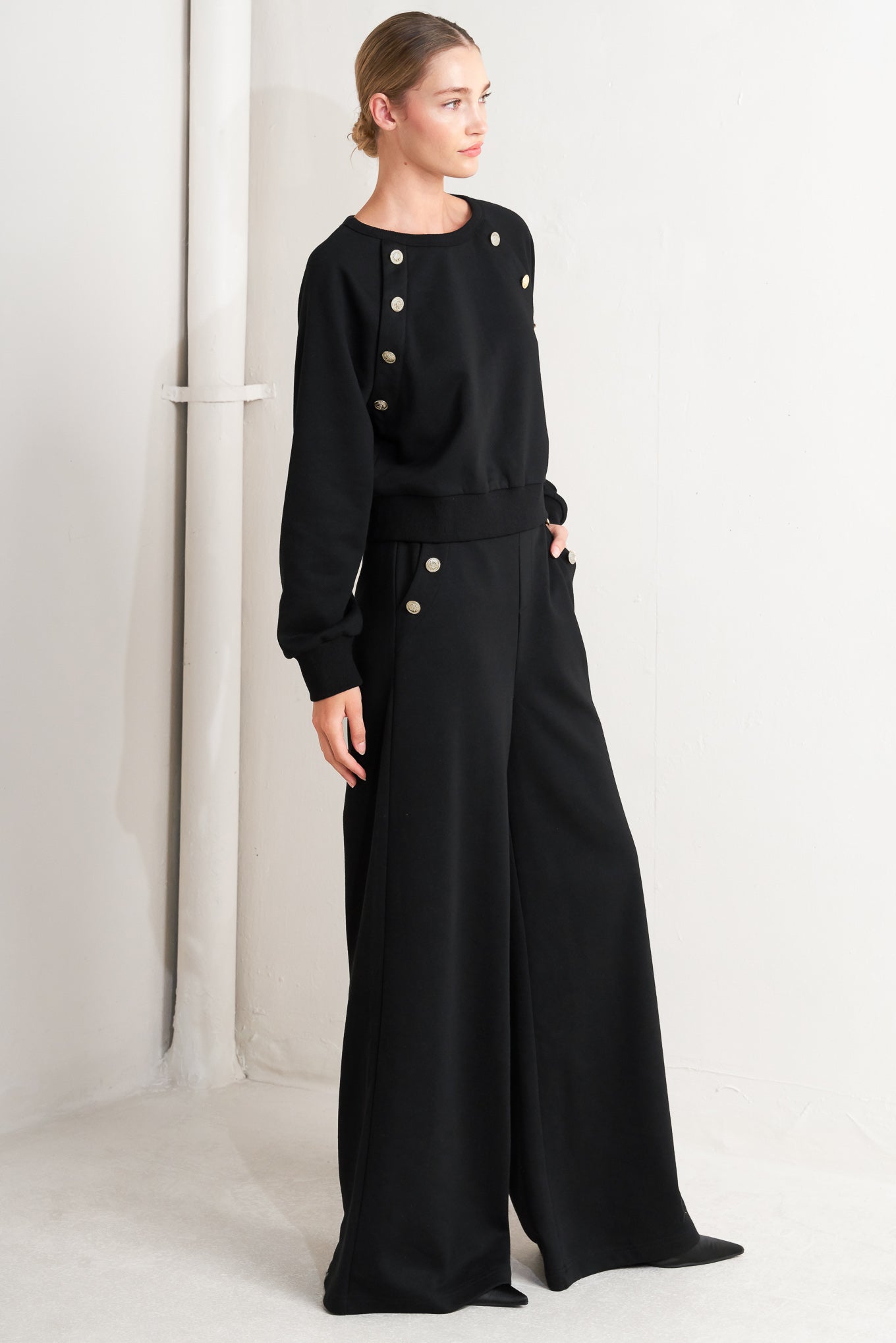 A solid woven top featuring crew neckline, long sleeve and button detail