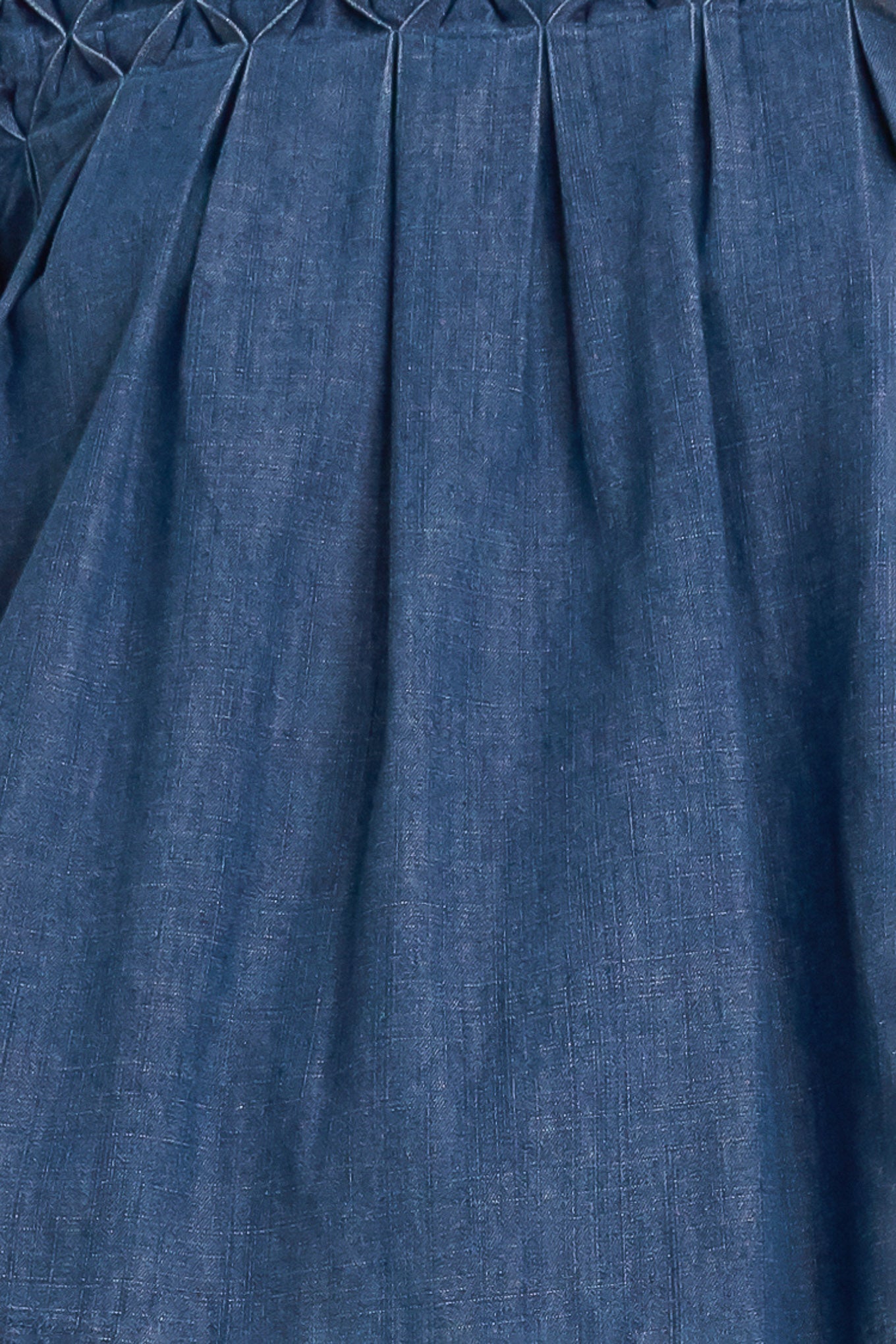 A chambray top featuring round neckline, honeycomb smocked, short bubble sleeve and back button closure