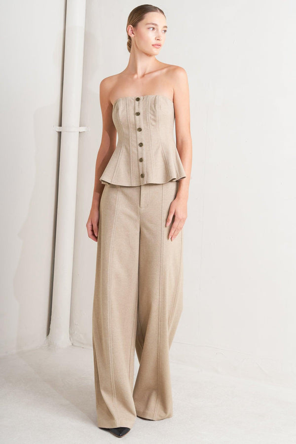 A solid knit top featuring strapless, front button detail and back zipper closure.