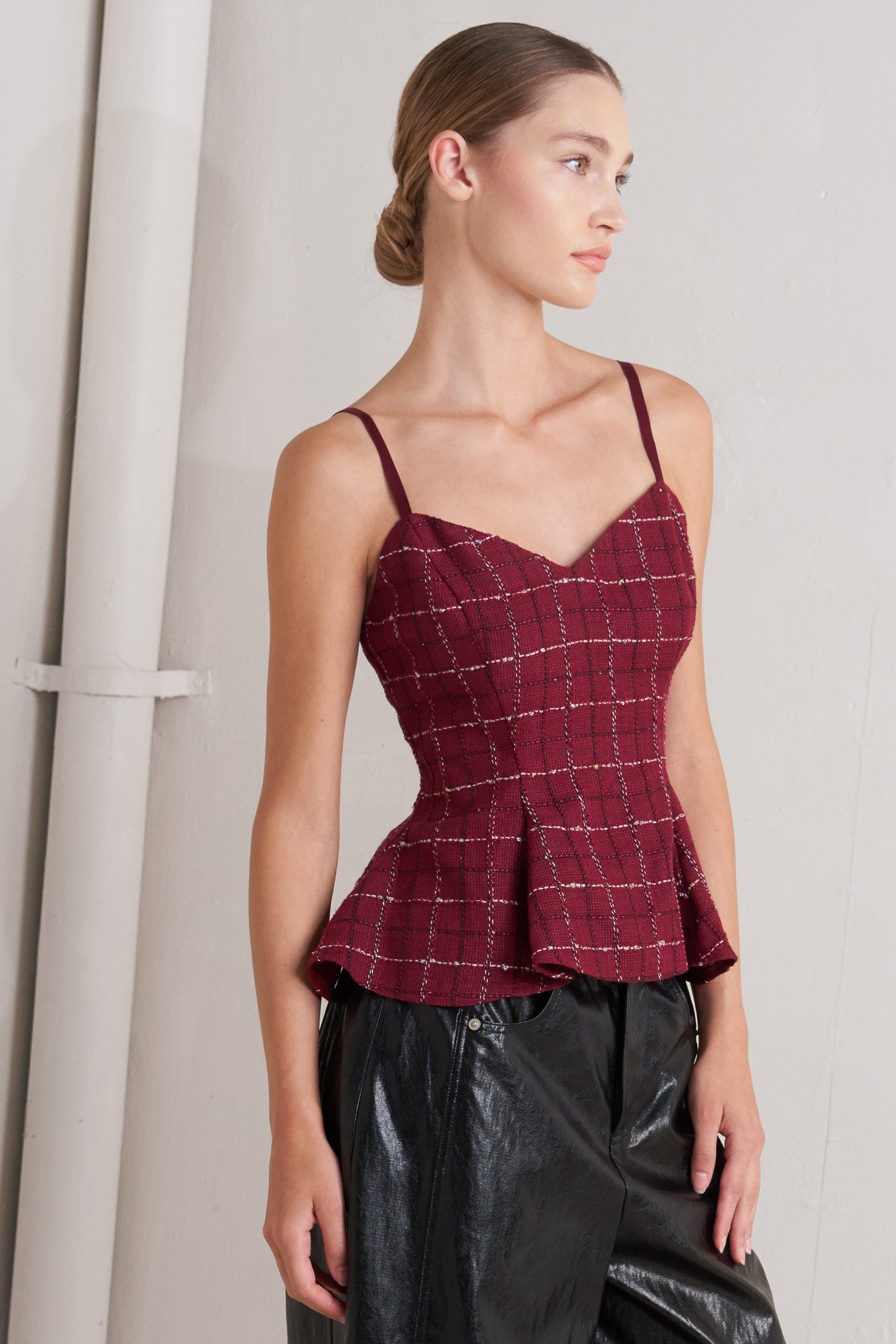 A tweed cami top featuring straps, peplum and back zipper closure