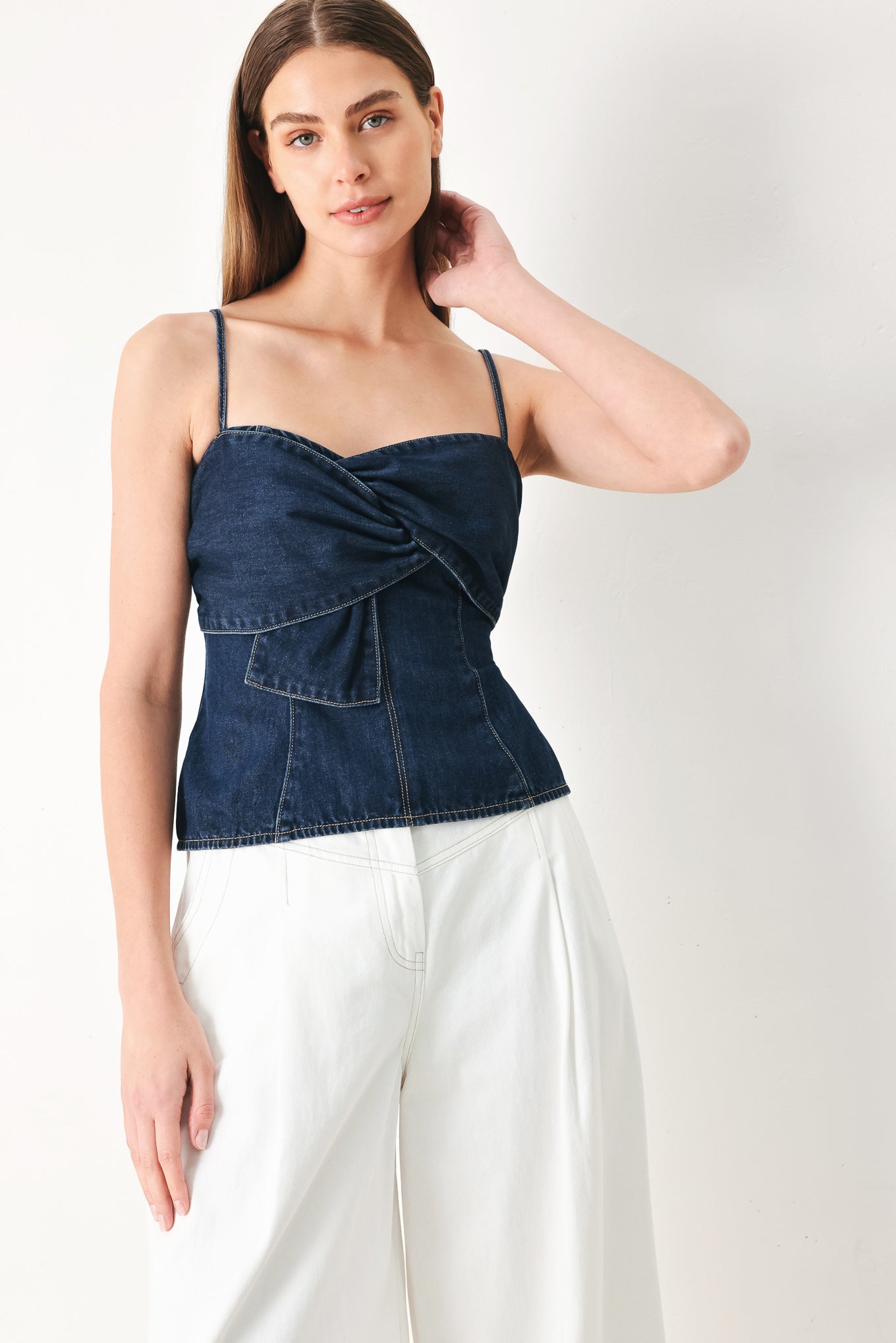 Woman wearing a denim top featuring front twist details, straps and back zipper closure | FREEMARKET | Flying Tomato