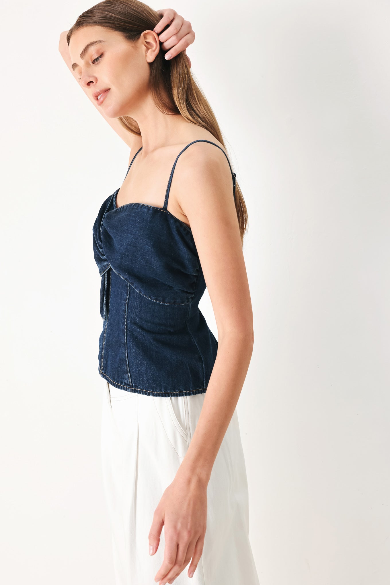 Woman wearing a denim top featuring front twist details, straps and back zipper closure | FREEMARKET | Flying Tomato