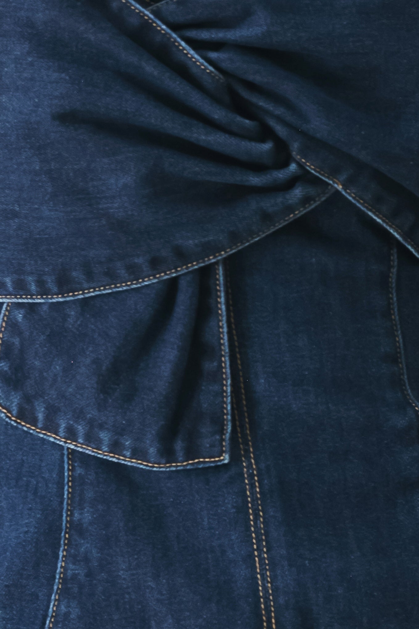 Close-up of a blue denim fabric with stitching details | FREEMARKET | Flying Tomato