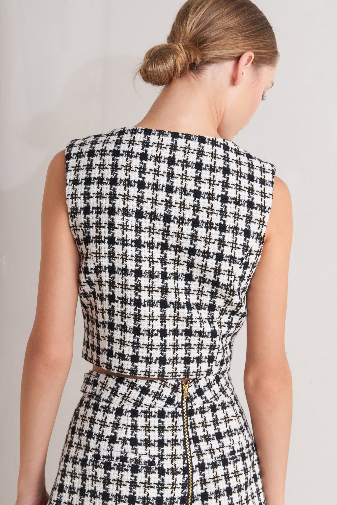 A tweed vest featuring round neckline, sleeveless and front button down.
