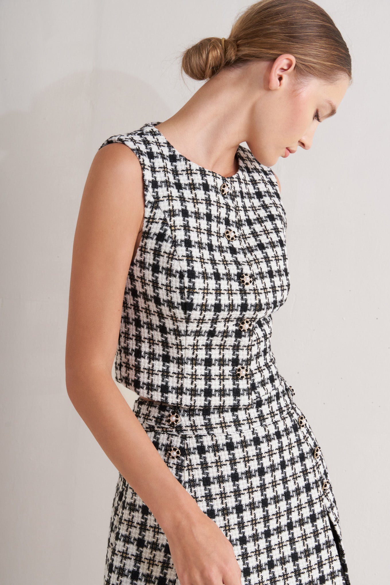 A tweed vest featuring round neckline, sleeveless and front button down.