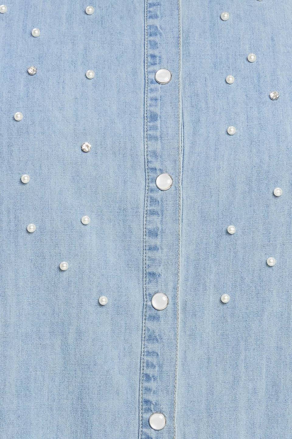 Woman wearing a light blue denim shirt on a beige background - Flying Tomato