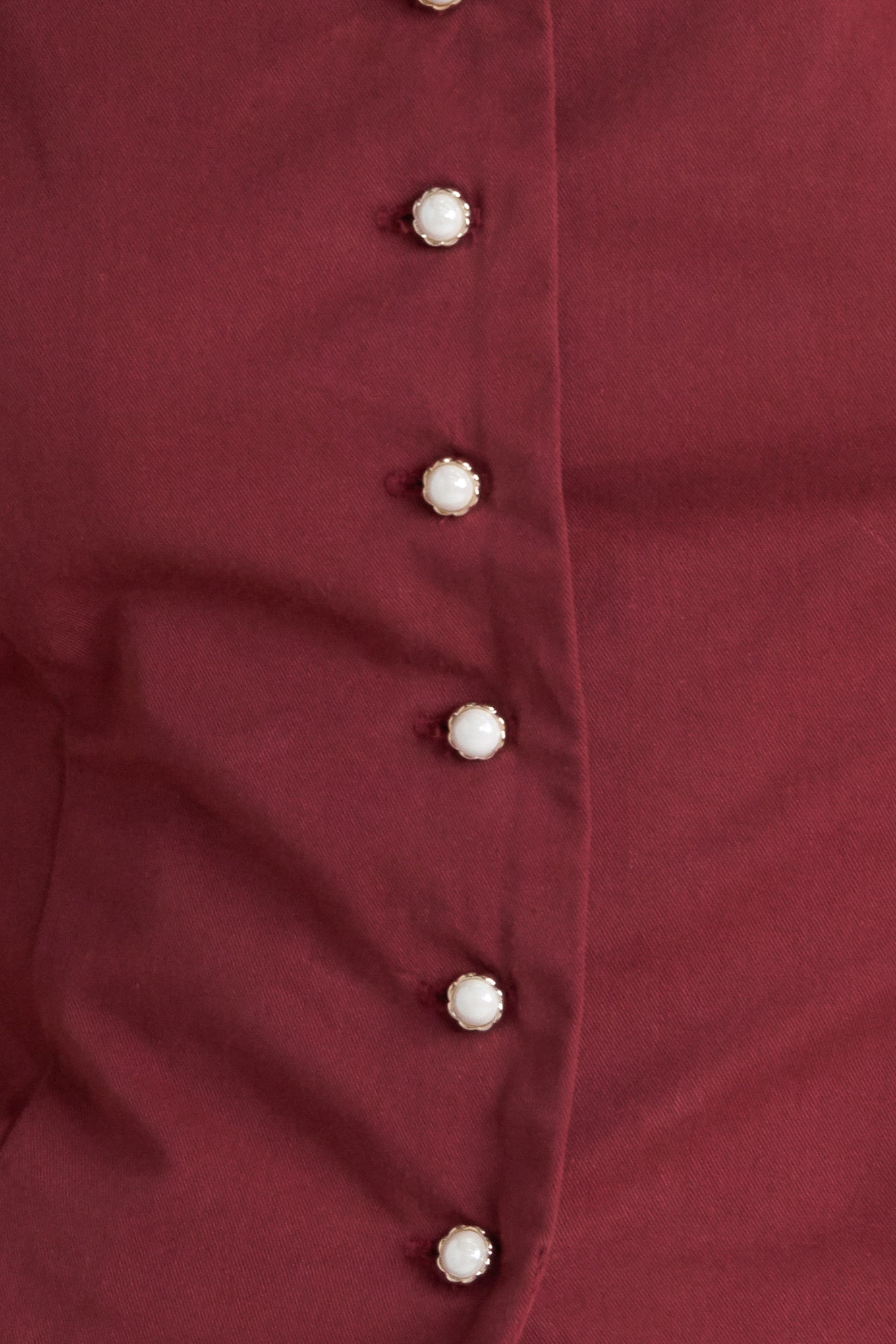 A solid woven top featuring scalloped square neckline, 3/4 sleeve and front button down closure