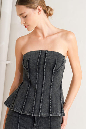 A washed denim top featuring strapless neckline and back zipper closure