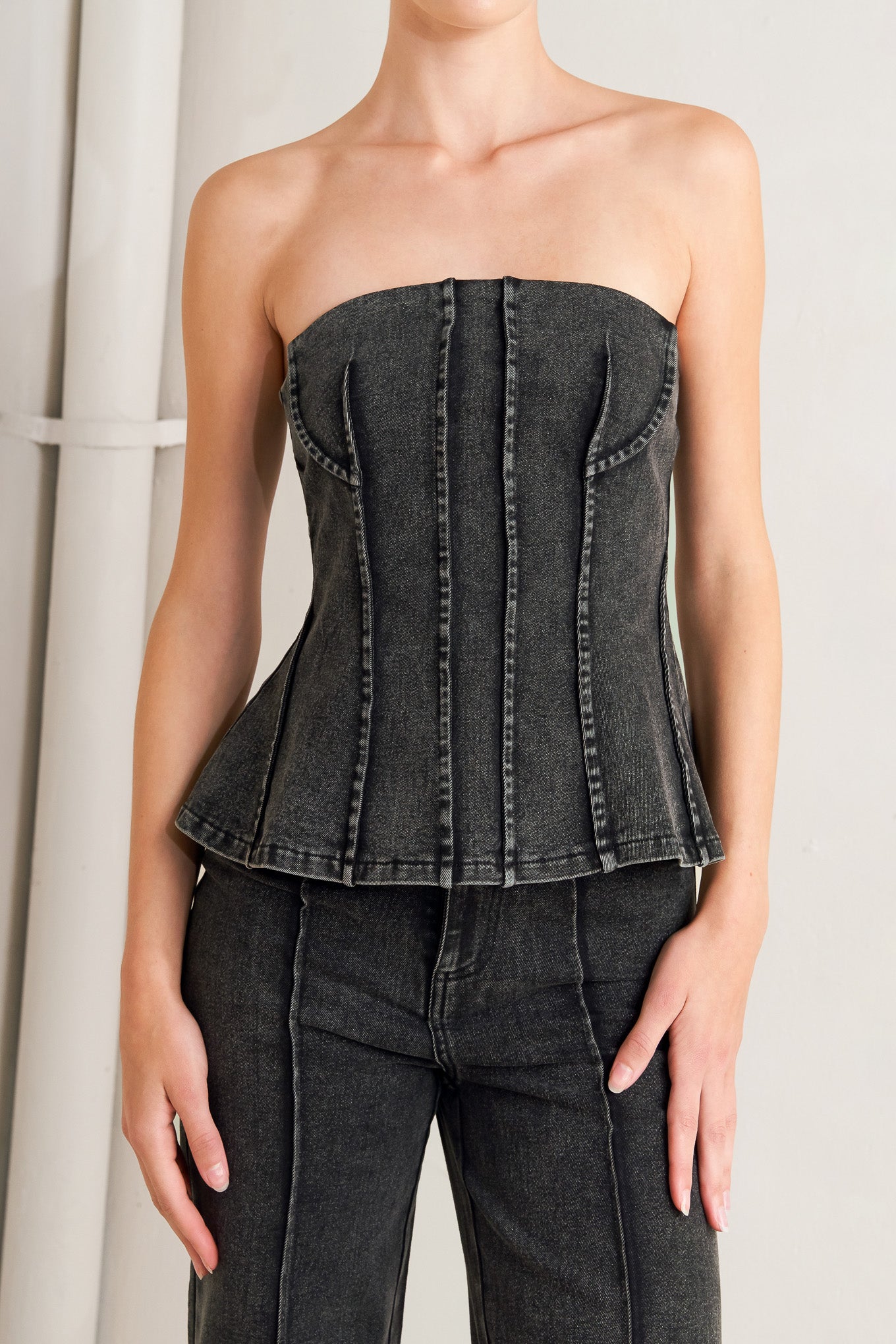 A washed denim top featuring strapless neckline and back zipper closure