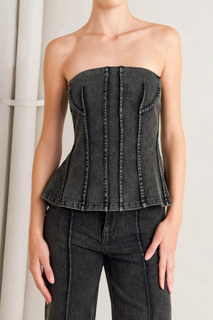 A washed denim top featuring strapless neckline and back zipper closure