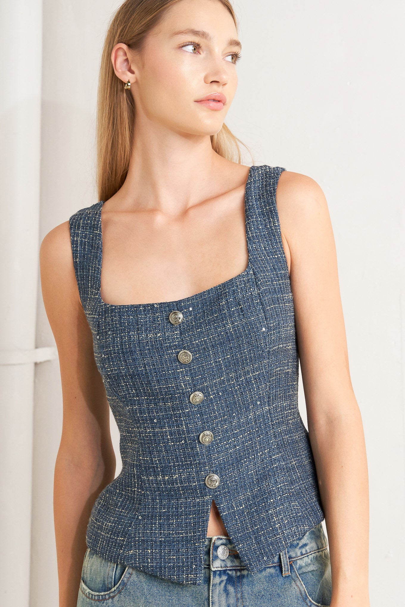 A tweed top featuring square neckline, sleeveless, button down detail and back zipper closure