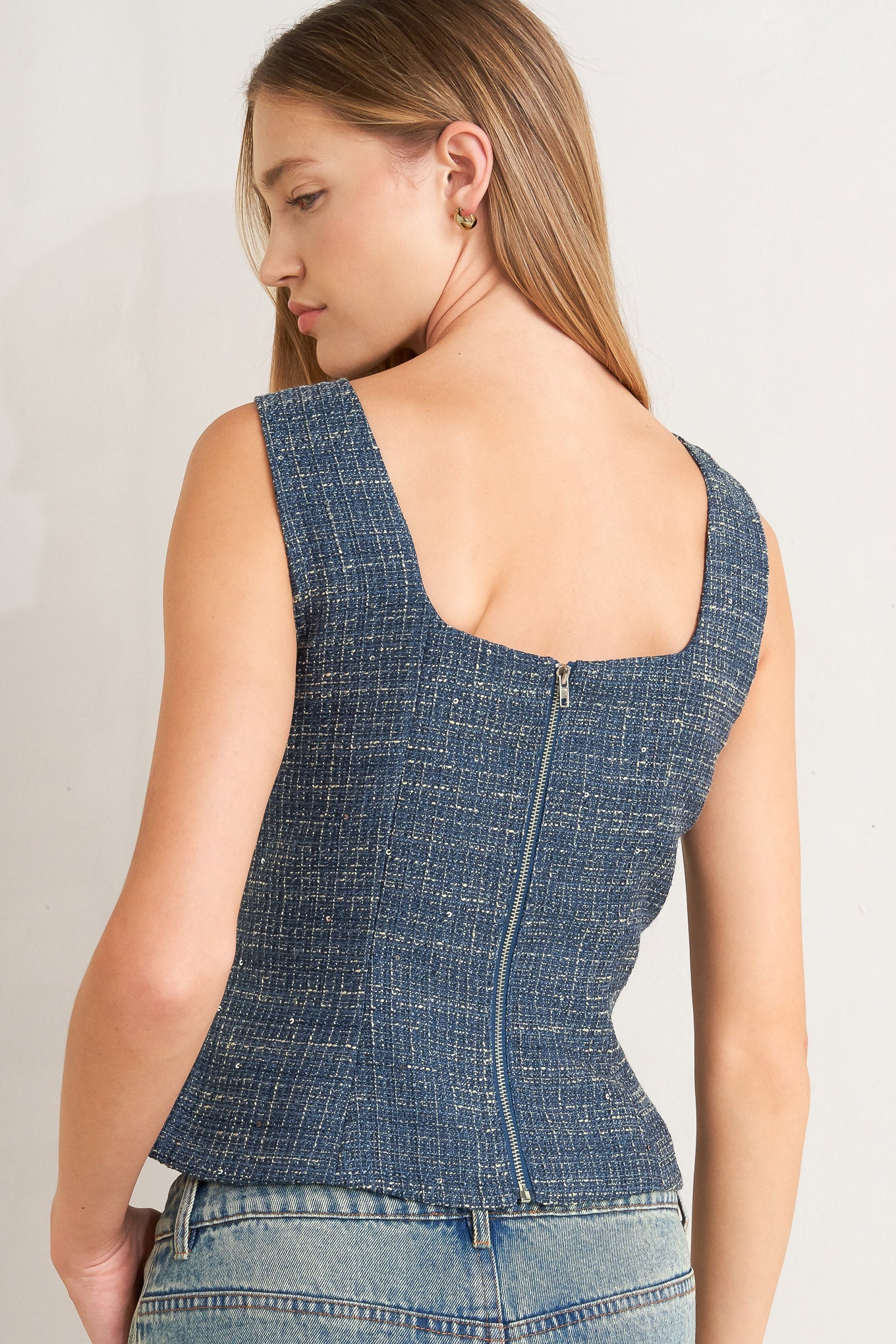A tweed top featuring square neckline, sleeveless, button down detail and back zipper closure