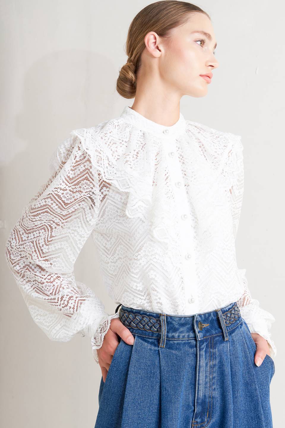 A woven lace top featuring high neckline, ruffles, long sleeve with cuff, button down closure and cami