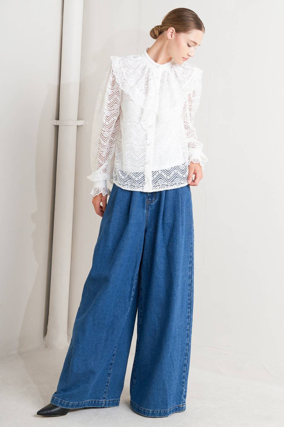 A woven lace top featuring high neckline, ruffles, long sleeve with cuff, button down closure and cami