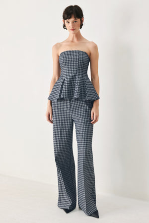 Woman wearing a strapless houndstooth patterned tube top with peplum and back zipper closure | FREEMARKET