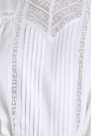 A solid woven top featuring ruffled high neck, pintuck and lace inset, short puff sleeve and back neck button closure

Details:

Self: 100% Cotton Exclusive of Decoration

Size & Fit

- Model is 5`8" And Wearing Size Small
- Measurements Taken From Size Small
- Approx. Length: 23"