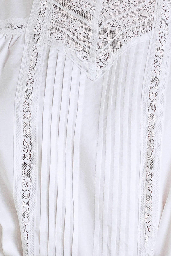 A solid woven top featuring ruffled high neck, pintuck and lace inset, short puff sleeve and back neck button closure

Details:

Self: 100% Cotton Exclusive of Decoration

Size & Fit

- Model is 5`8" And Wearing Size Small
- Measurements Taken From Size Small
- Approx. Length: 23"