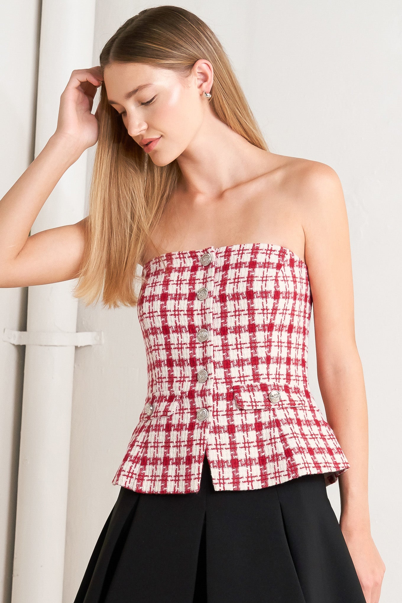 A tweed top featuring strapless, button down detail, faux pockets and back zipper closure