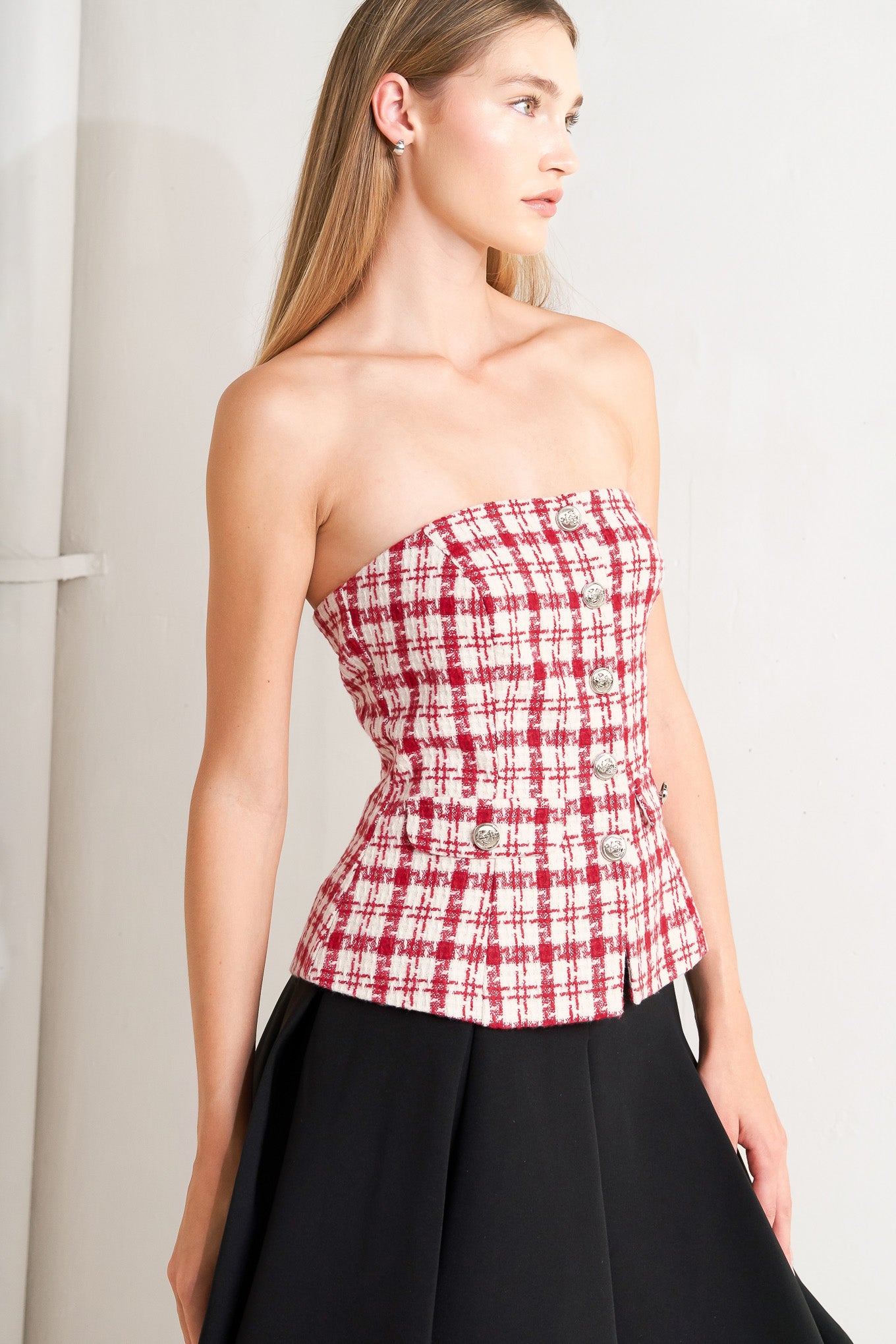 A tweed top featuring strapless, button down detail, faux pockets and back zipper closure