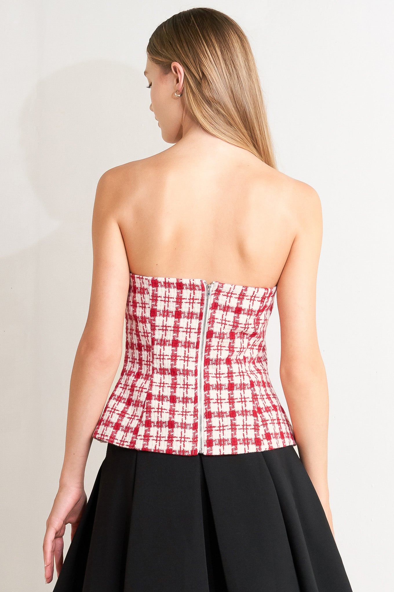 A tweed top featuring strapless, button down detail, faux pockets and back zipper closure