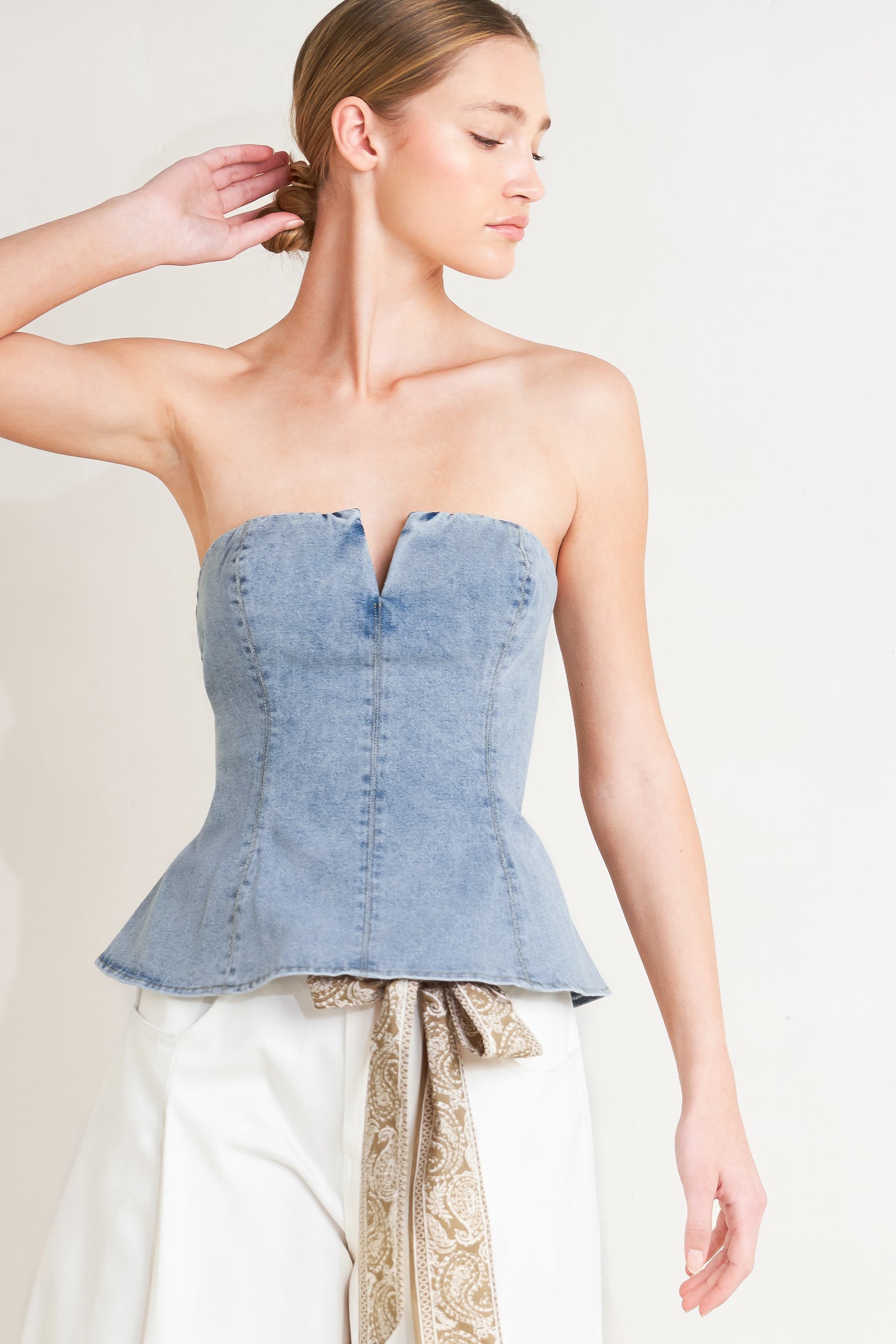 
A washed denim top featuring strapless, V cut out, peplum and back zipper closure

Details:

Self : 85% Cotton 14% Polyester 1% Spandex&nbsp;
Lining : 90% Polyester 10% Cotton

Size &amp; Fit

- Model is 5`8" And Wearing Size Small
- Measurements Taken From Size Small
- Approx. Length: 14"