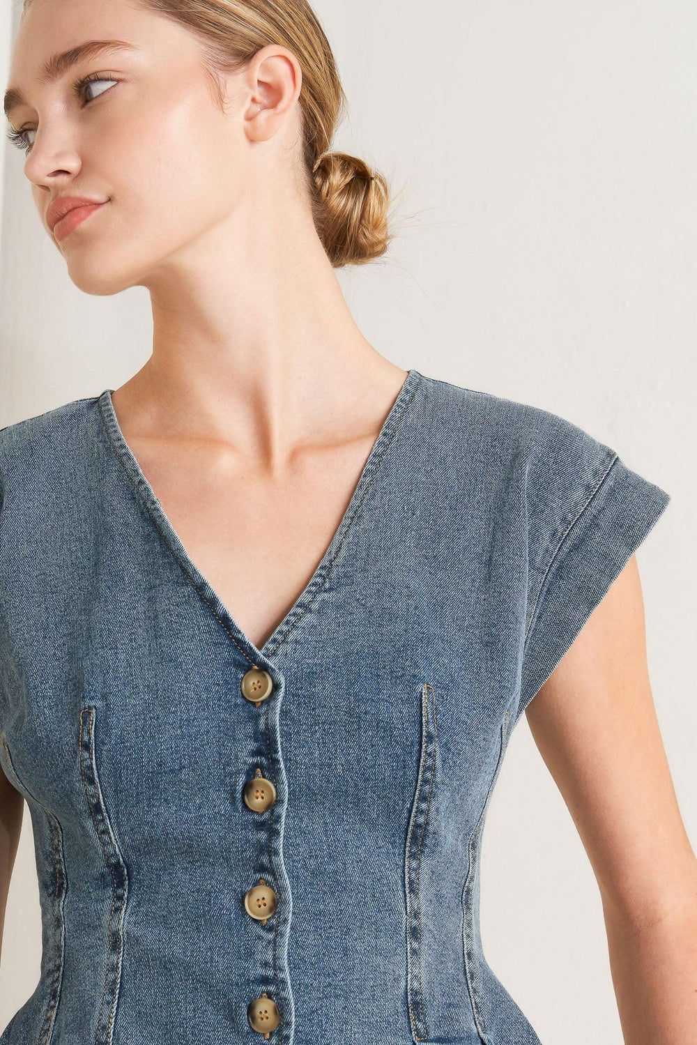 A washed denim top featuring V neckline, short sleeve, front button sown and peplum. Matching pant FP1946

Details:

Self: 99% Cotton 1% Spandex

Size & Fit

-Model is 5`8" And Wearing Size Small
-Measurements Taken From Size Small
-Approx. Length: 23"
