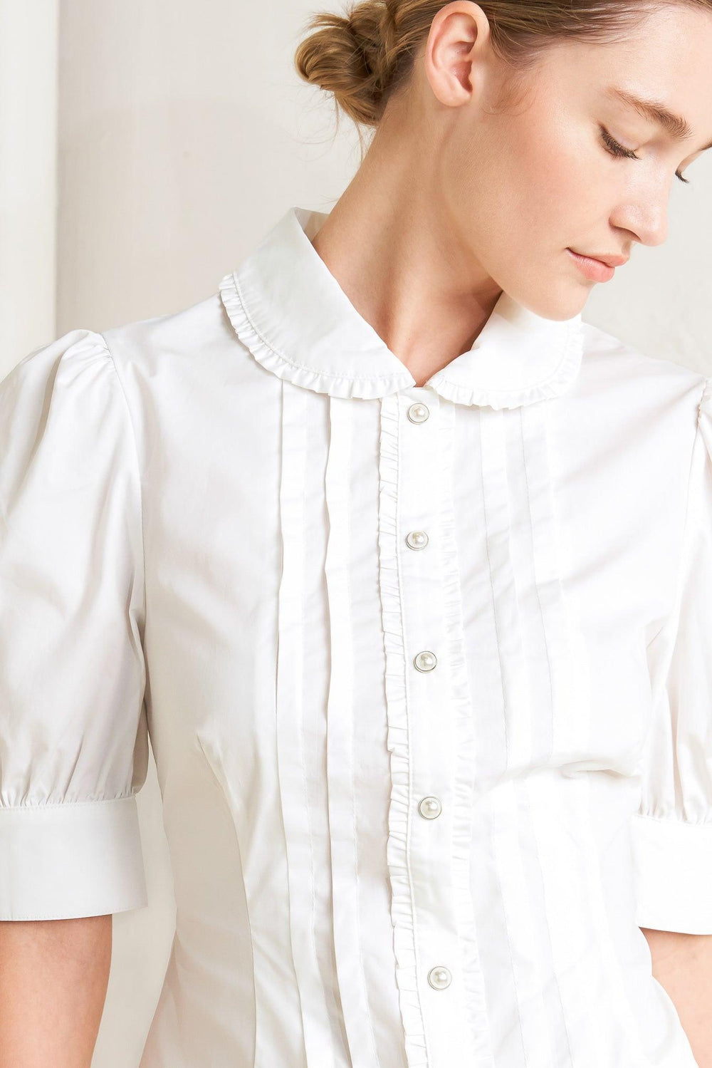 
A solid woven top featuring round collar with ruffle edge, short puff sleeve with cuff, front pintuck, ruffle edge placket with jewel button

Details:

Self : 100% Cotton

Size &amp; Fit

- Model is 5`8" And Wearing Size Small
- Measurements Taken From Size Small
- Approx. Length: 22" Flying Tomato