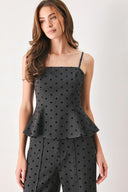 Woman wearing a spaghetti strap charcoal grey top with black polka dots and a peplum waist | FREEMARKET