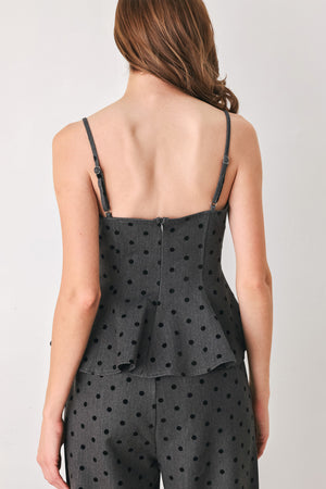 Woman wearing a spaghetti strap charcoal grey top with black polka dots and a peplum waist | FREEMARKET