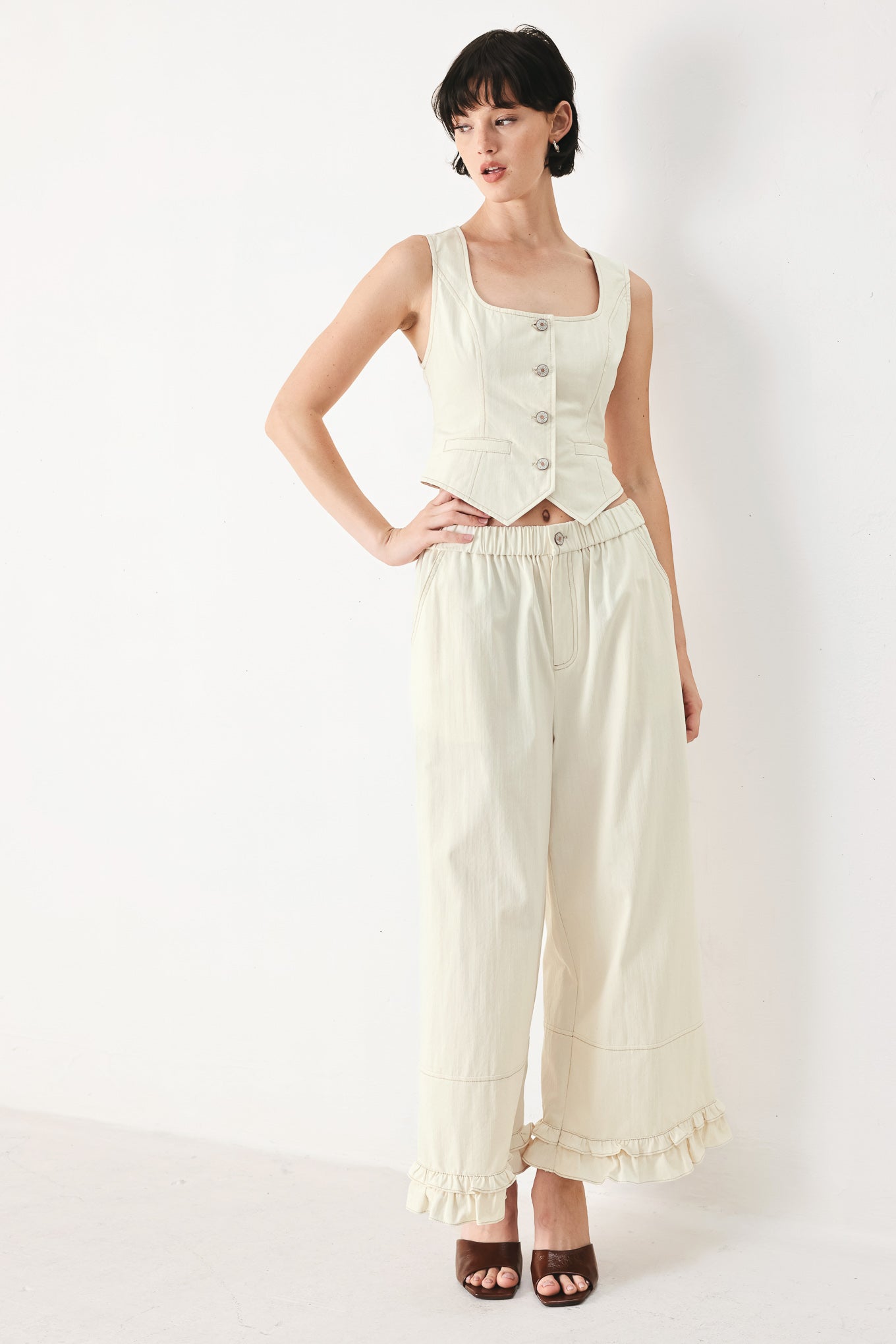 Woman wearing an oatmeal solid woven vest with U neckline, sleeveless and front button down | FREEMARKET