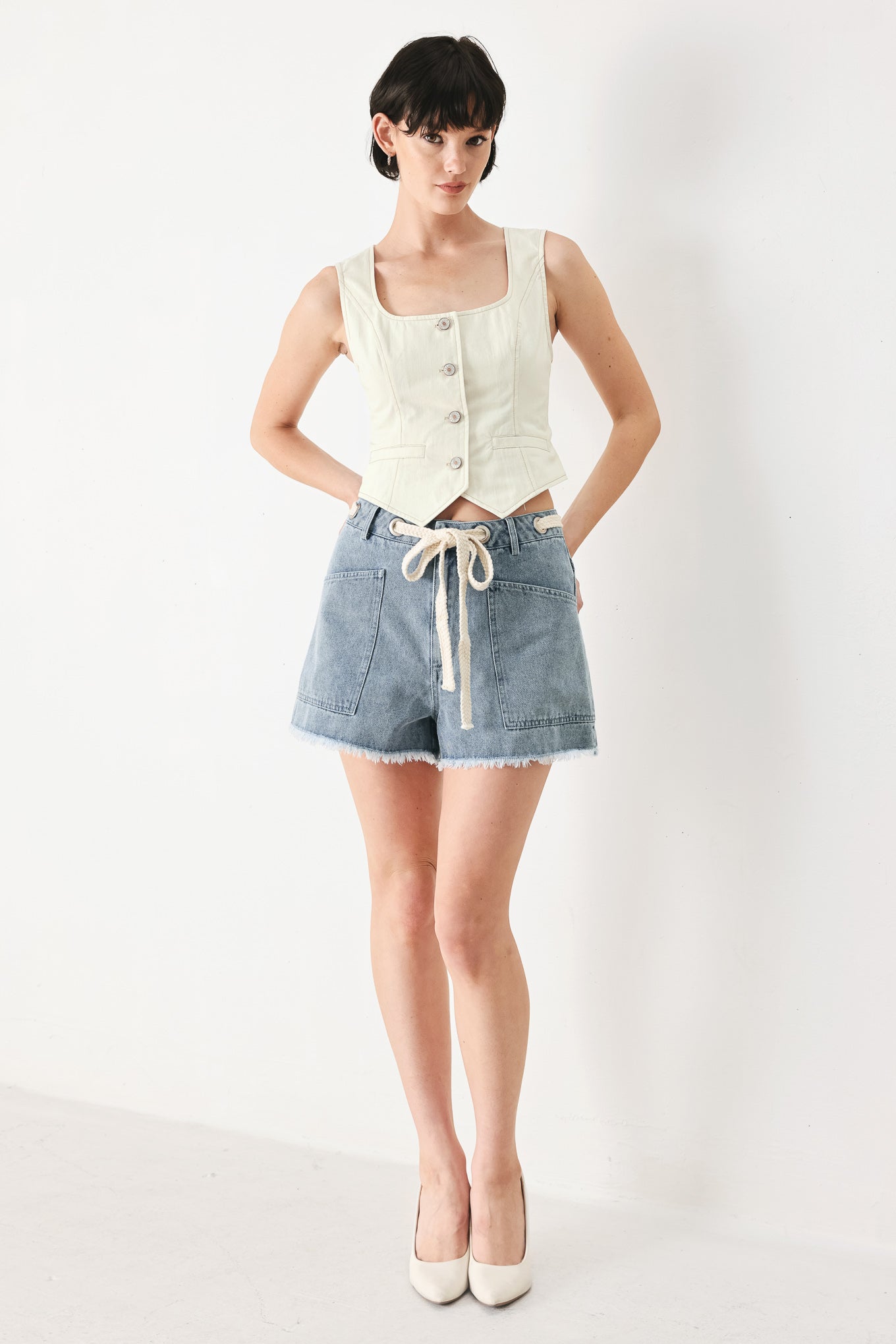Woman wearing an oatmeal solid woven vest with U neckline, sleeveless and front button down | FREEMARKET