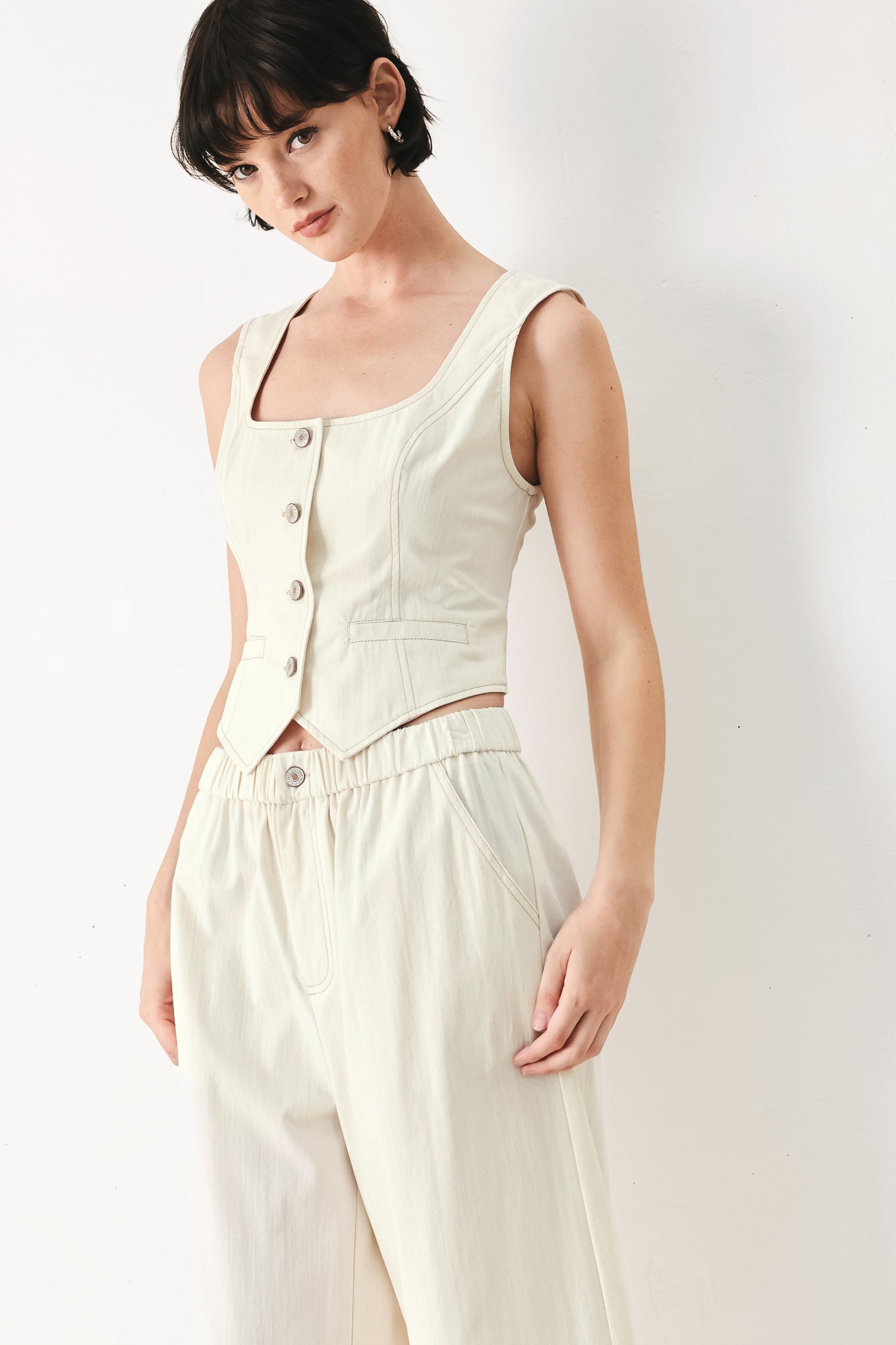 Woman wearing an oatmeal solid woven vest with U neckline, sleeveless and front button down | FREEMARKET