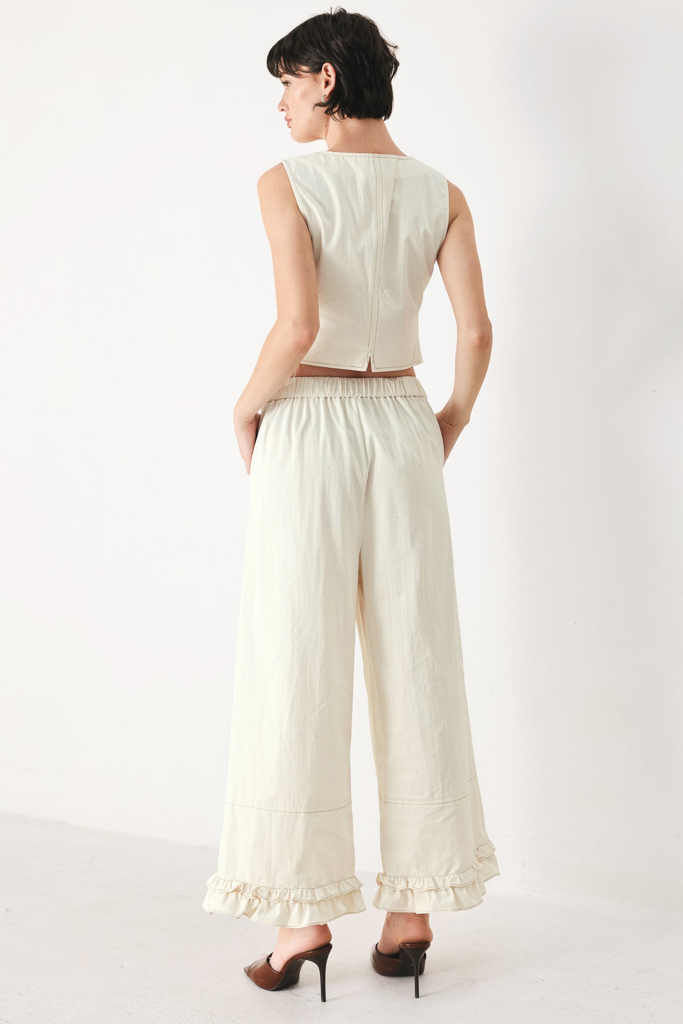 Woman wearing an oatmeal solid woven vest with U neckline, sleeveless and front button down | FREEMARKET