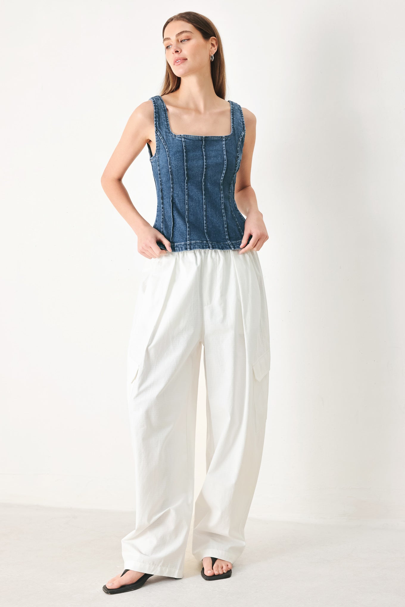 Woman wearing a sleeveless denim corset top with square neckline, peplum and back zipper closure | FREEMARKET | Flying Tomato
