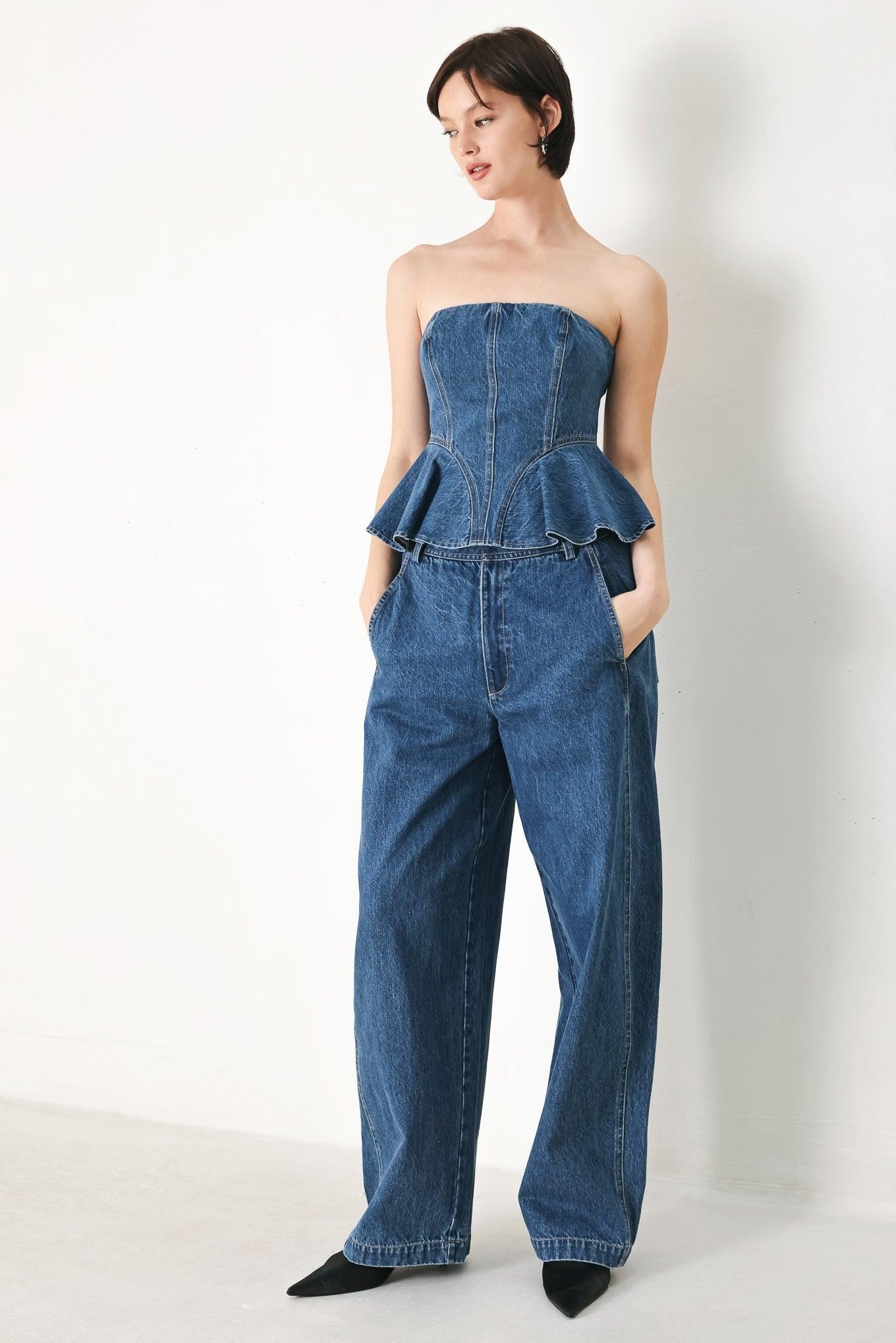 A washed denim top featuring strapless, ruffled peplum and back zipper closure