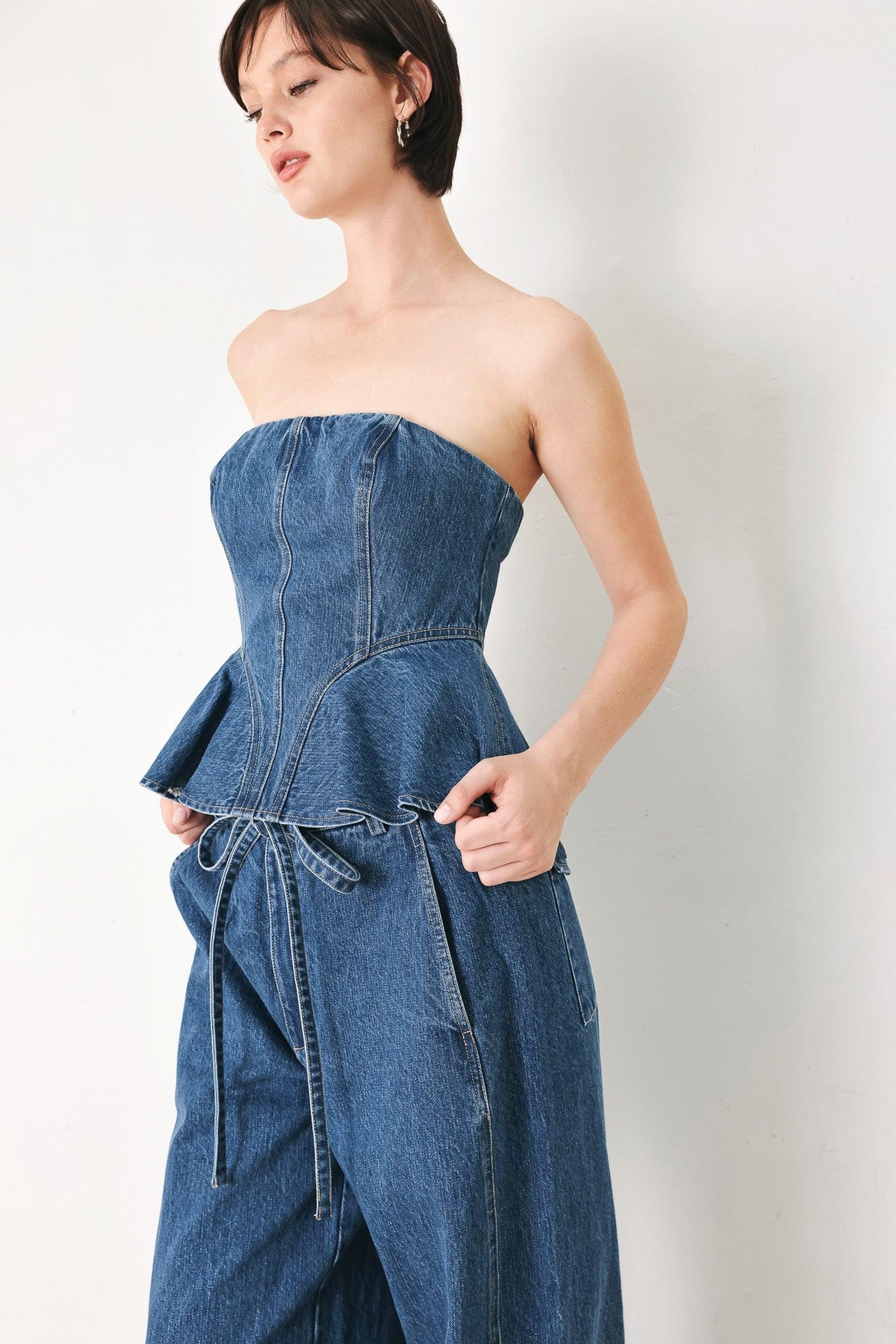 A washed denim top featuring strapless, ruffled peplum and back zipper closure