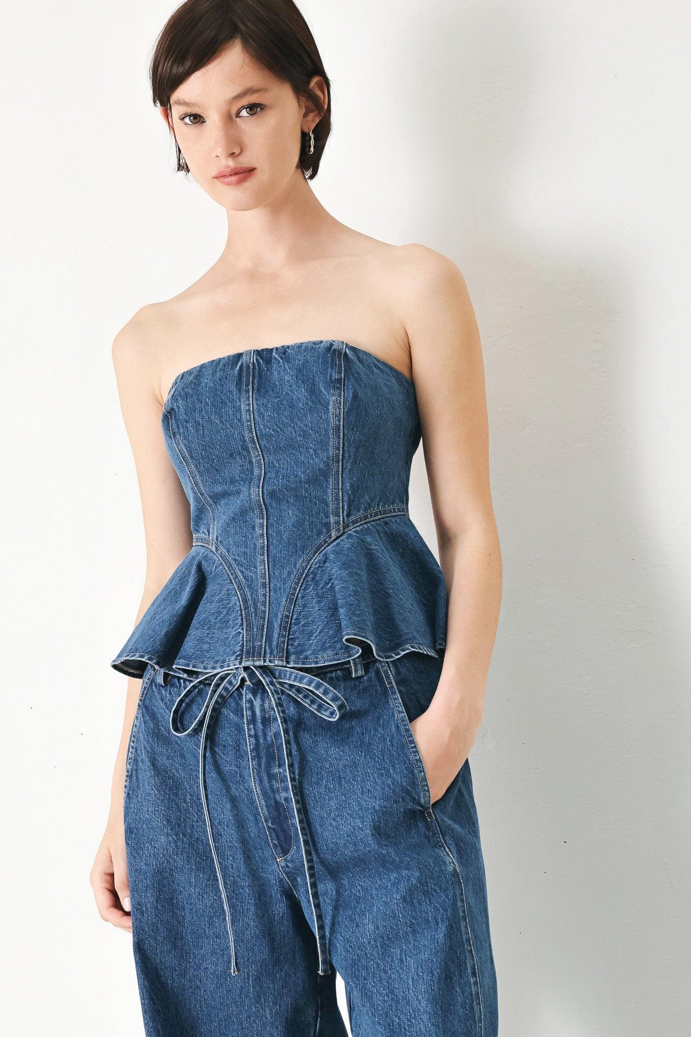 A washed denim top featuring strapless, ruffled peplum and back zipper closure