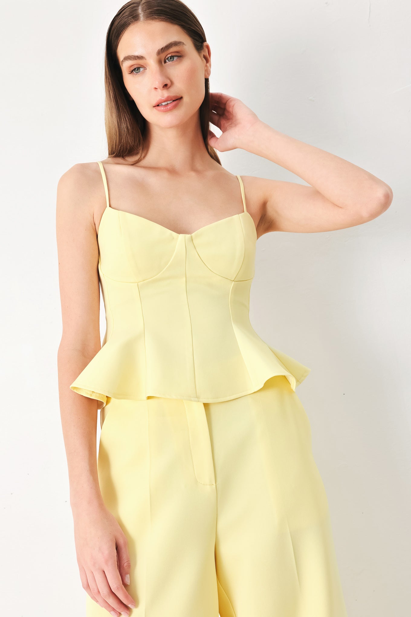 Woman wearing a yellow peplum cami top with back zipper closure | FREEMARKET | Flying Tomato