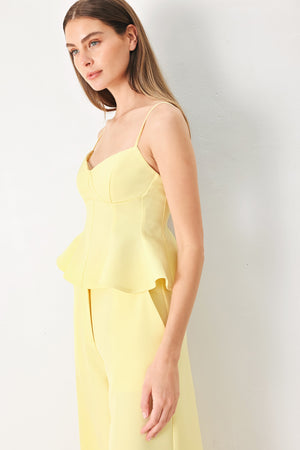 Woman wearing a yellow peplum cami top with back zipper closure | FREEMARKET | Flying Tomato