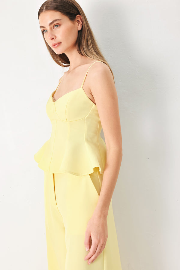 Woman wearing a yellow peplum cami top with back zipper closure | FREEMARKET | Flying Tomato