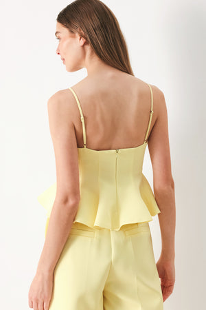 Woman wearing a yellow peplum cami top with back zipper closure | FREEMARKET | Flying Tomato