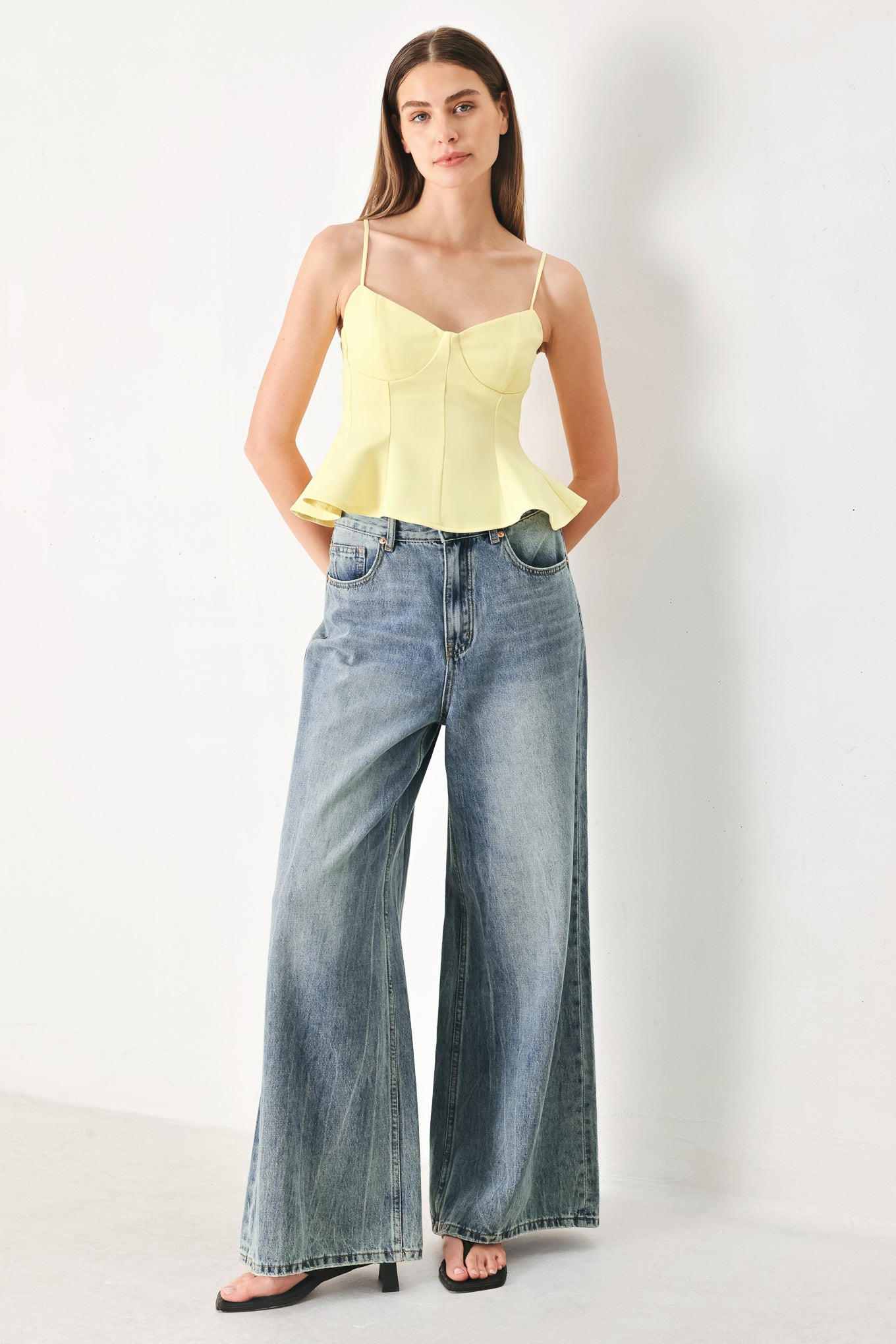 Woman wearing a yellow peplum cami top with back zipper closure | FREEMARKET | Flying Tomato