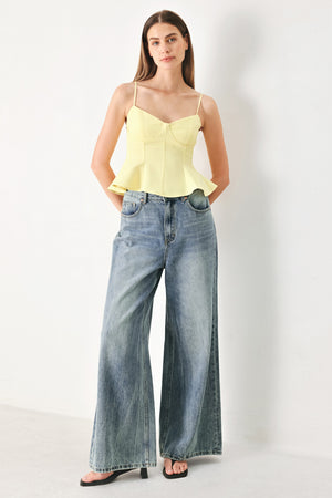 Woman wearing a yellow peplum cami top with back zipper closure | FREEMARKET | Flying Tomato