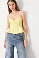 Woman wearing a yellow peplum cami top with back zipper closure | FREEMARKET | Flying Tomato