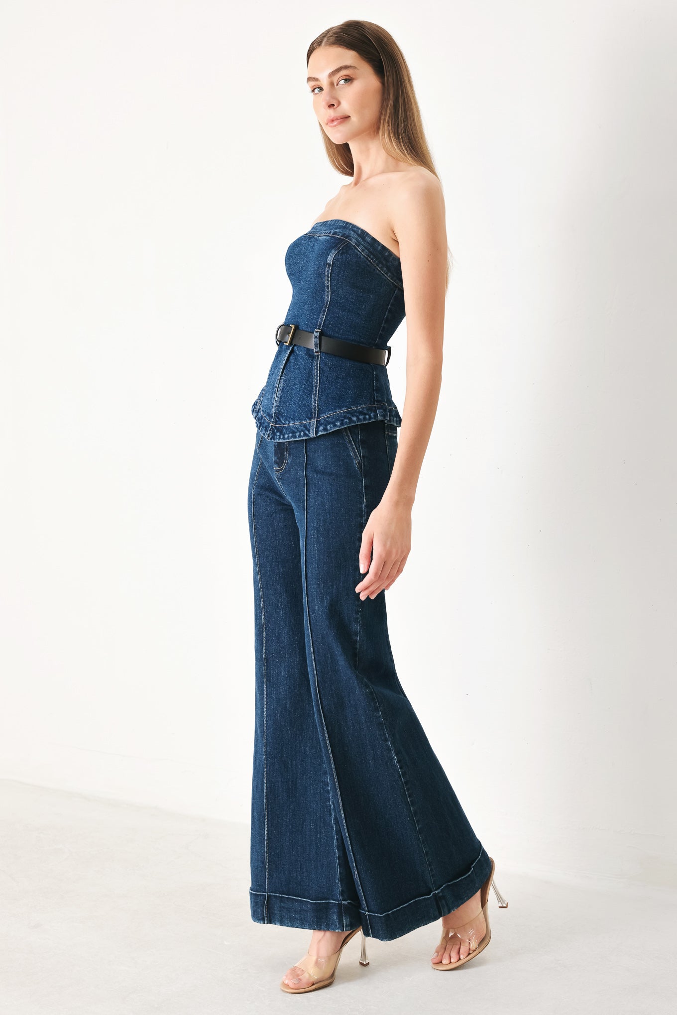Woman wearing a strapless denim denim tube top featuring contrasting belt, front slit peplum and back zipper closure | FREEMARKET | Flying Tomato