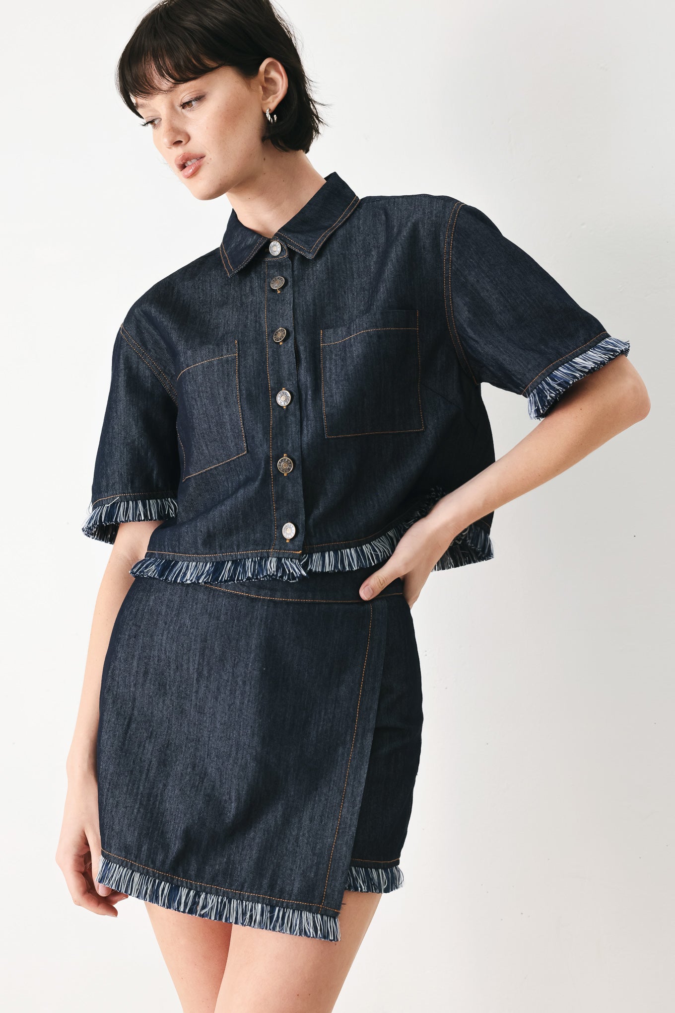 Woman wearing a dark denim crop jacket featuring short sleeve with fray edge and button down closure | FREEMARKET